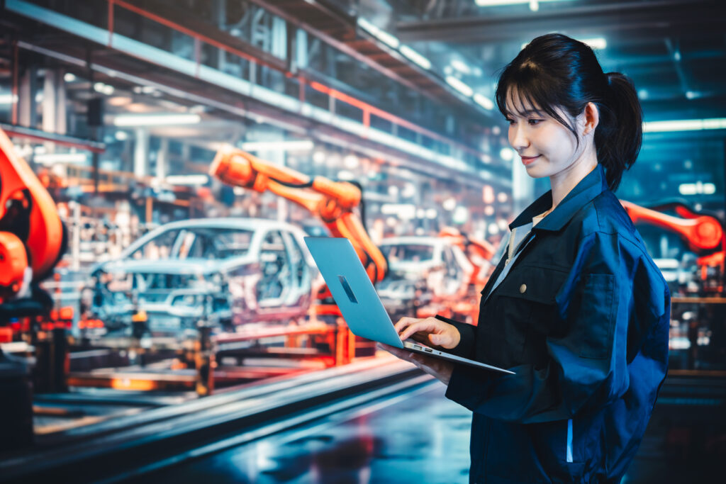 工場の生産ラインでパソコンを使う若い女性 - Semicon.TODAY