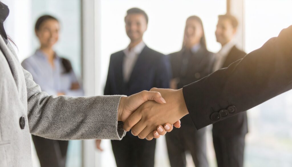 チームと共に握手するビジネスシーン - Semicon.TODAY