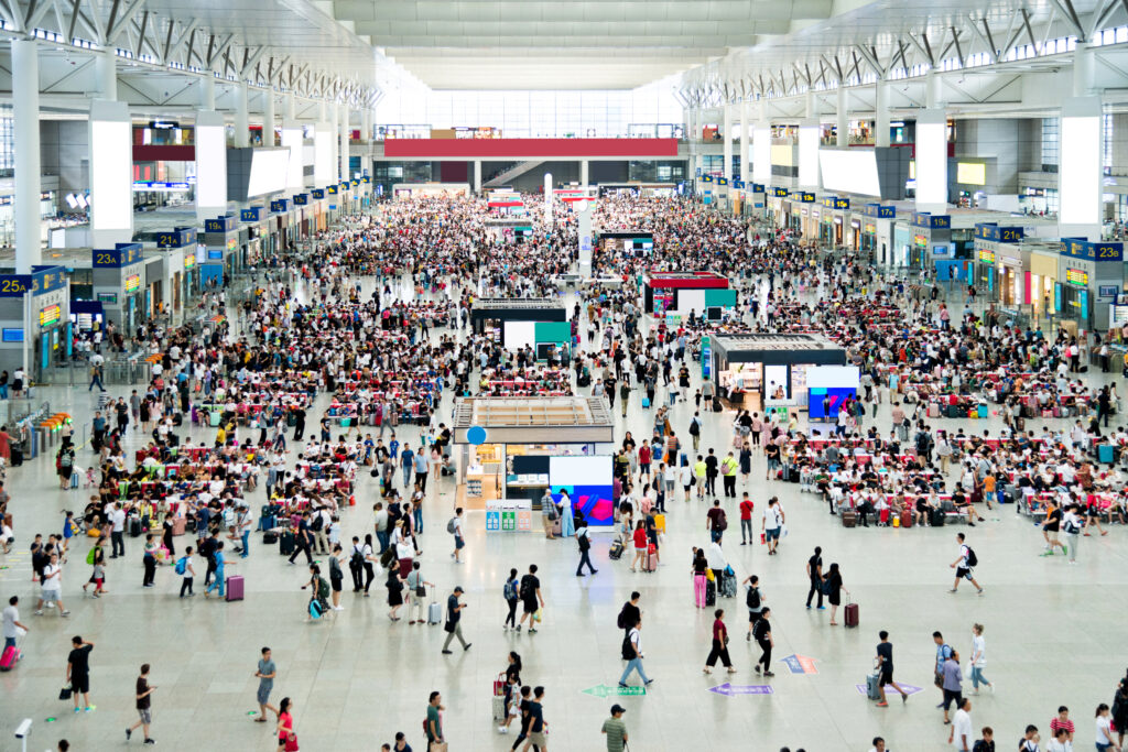 Large group of people waiting at train station hall - Semicon.TODAY