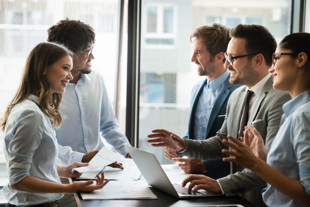 Happy business people having fun and chatting at workplace office - Semicon.TODAY