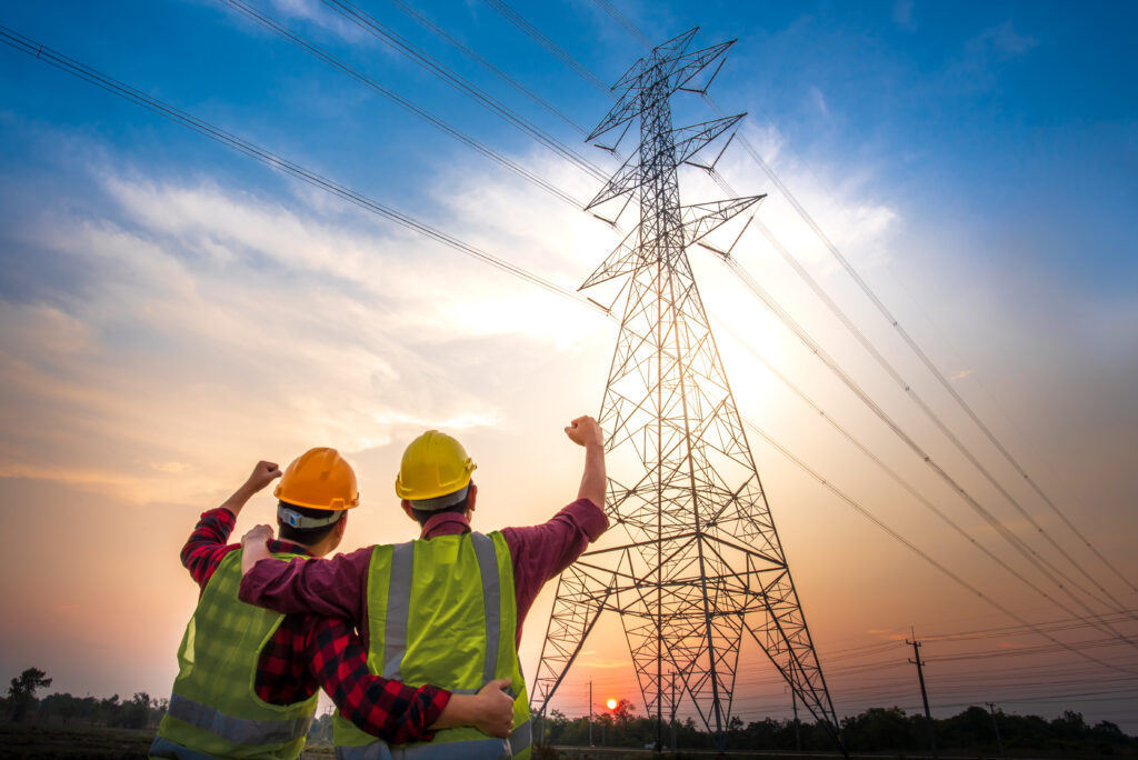 Pictures of two electrical engineers standing at the power station to see success and rejoice With the production of electric power - Semicon.TODAY