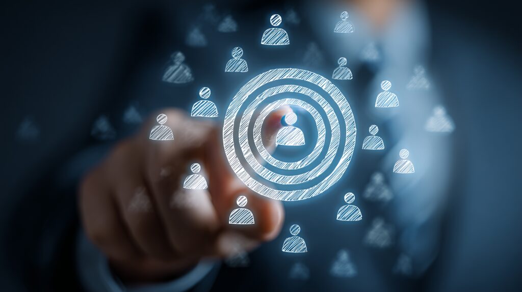 Laser focus on your target audience to drive business growth and connect with your ideal customers using innovative targeting strategies - SEMICON.TODAY Finger touching a glowing circular target made of rings, surrounded by small user icons, symbolizing audience targeting or recruitment.