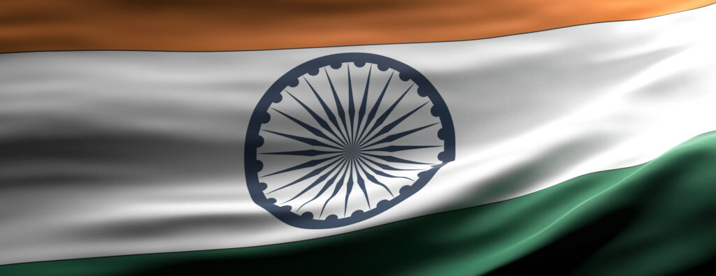 Waving Indian flag with saffron top, white middle featuring the blue Ashoka Chakra, and green bottom stripe.
