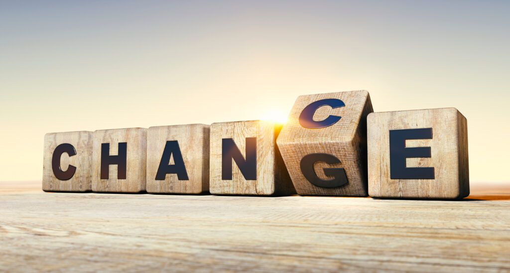Wooden blocks spell the word CHANGE at sunset, symbolizing transformation and new beginnings