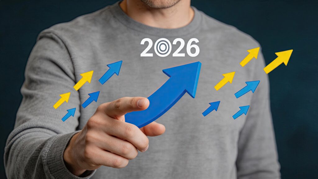 Business growth strategy concept for 2026 man pointing at rising arrow chart financial success and upward trend forecast planning for future economic development and market - SEMICON.TODAY Person in a gray shirt holds a large blue arrow pointing up, surrounded by small blue and yellow arrows, with '2026' on the chest, symbolizing growth toward 2026.